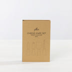 Gather 4 Piece Cheese Knife Set Multi-Coloured presented in a closed kraft cardboard gift box with illustrations of the four cheese utensils.