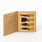 Gather 4 Piece Cheese Knife Set Acacia Black displayed in open gift packaging with four black cheese serving utensils and natural wooden handles.