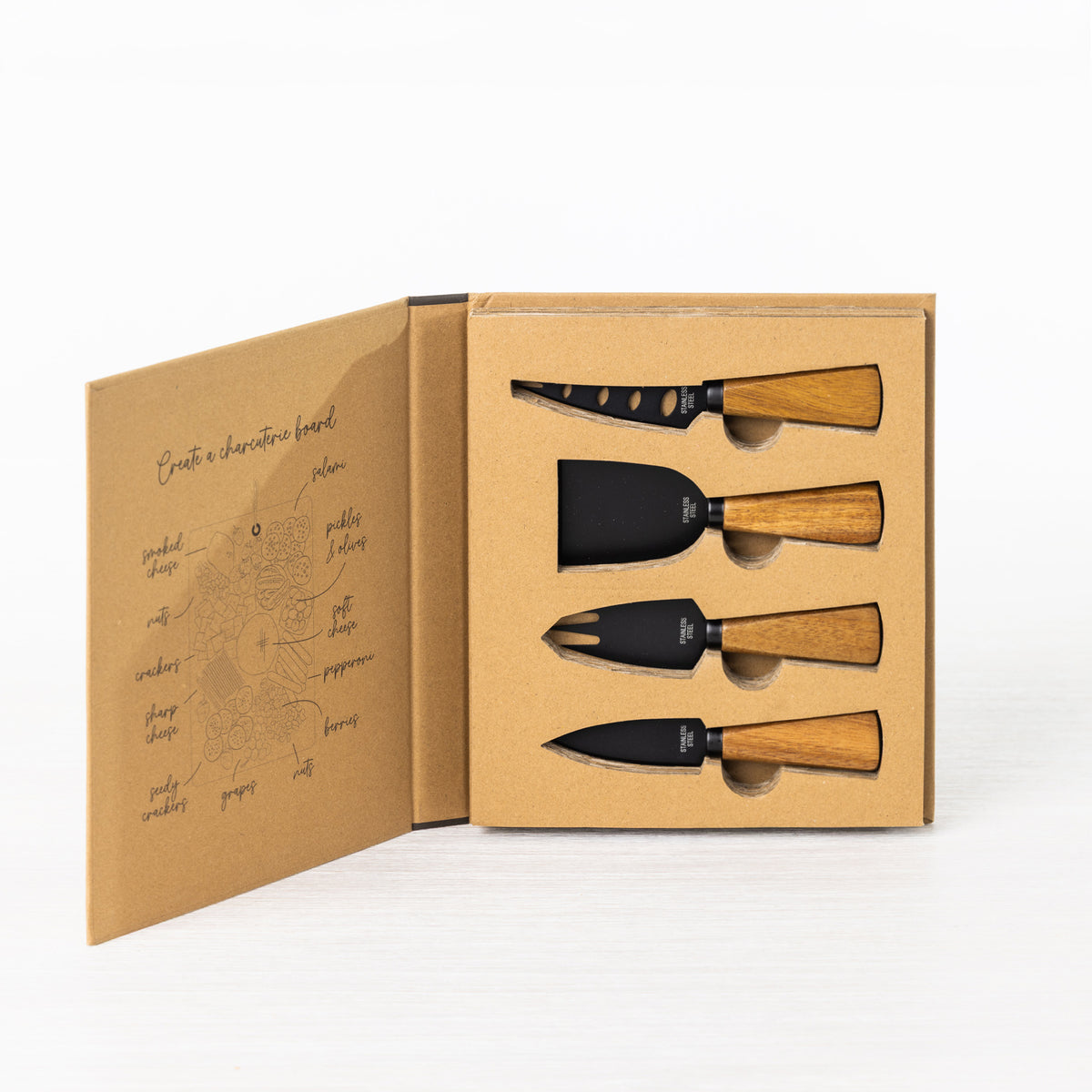 Gather 4 Piece Cheese Knife Set Acacia Black displayed in open gift packaging with four black cheese serving utensils and natural wooden handles.