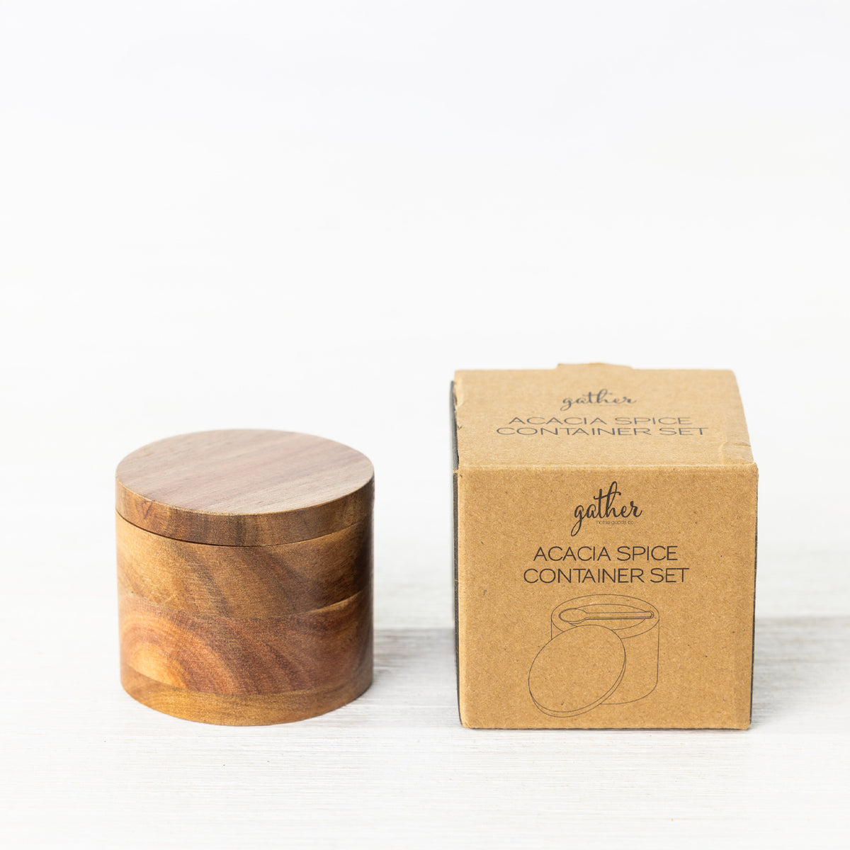 Gather Acacia Spice Container Set featuring a round natural acacia wood spice container with a fitted lid displayed beside its kraft cardboard packaging.