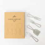 Gather 4 Piece Cheese Knife Set Silver featuring four stainless steel cheese serving utensils with modern open handles displayed beside the kraft cardboard packaging.