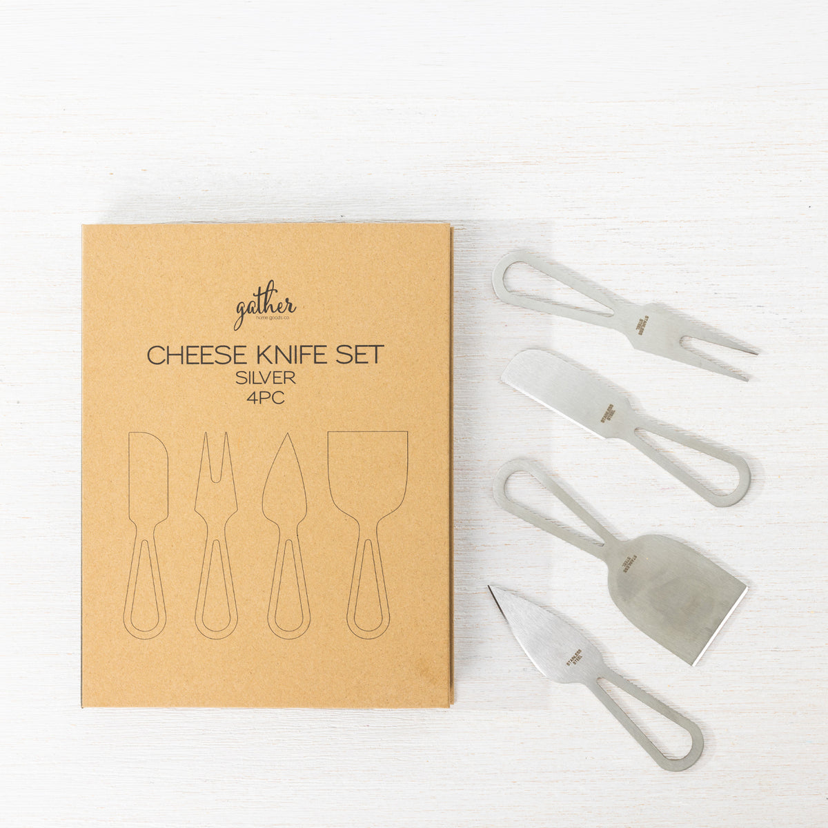 Gather 4 Piece Cheese Knife Set Silver featuring four stainless steel cheese serving utensils with modern open handles displayed beside the kraft cardboard packaging.