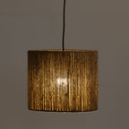 A cylindrical pendant light with a textured, vertically ribbed woven shade in a warm golden-brown tone, suspended by a black cord against a plain gray background.