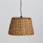 A woven natural fiber pendant lampshade with a black hanging cord, shown against a plain light gray background.