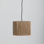 A cylindrical light shade wrapped in natural rope, suspended by a black cord against a plain light gray background.