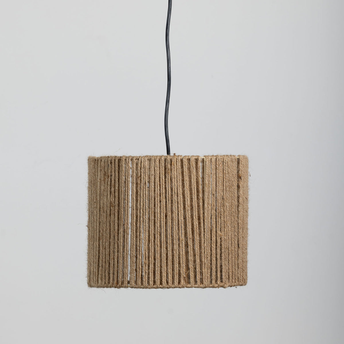 A light shade made from tightly wrapped natural jute rope, suspended from a black cord against a plain light gray background.