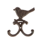 A decorative dark metal wall hook featuring a perched bird above two curved hooks is shown against a plain light background.
