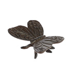 A decorative dark metal butterfly ornament with intricately patterned wings and small legs is shown against a plain light background.