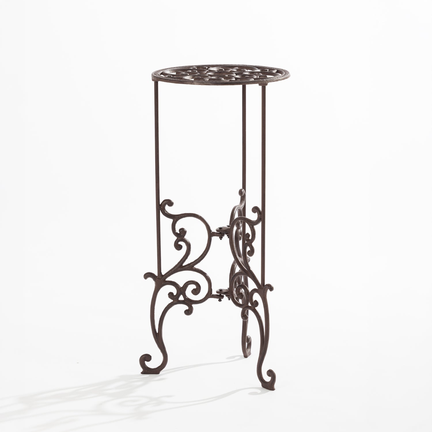 An ornate dark metal plant stand with a circular scrollwork top and decorative curved legs is shown against a plain light background.