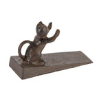 A decorative dark metal doorstop featuring a small cat figure with raised paws mounted on a wedge-shaped base is shown against a plain light background.