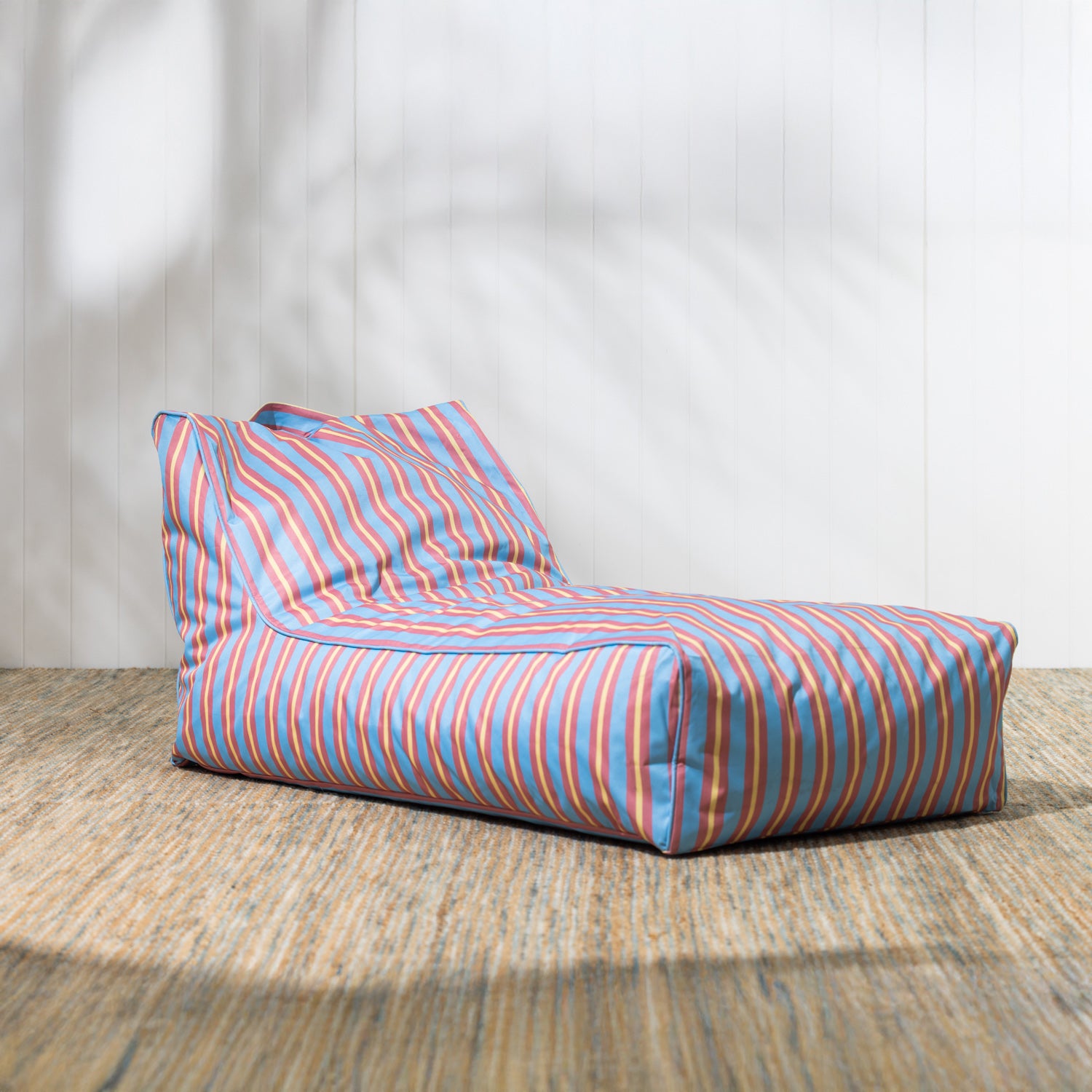 Striped bean bag chair on a wooden floor with a white wall background