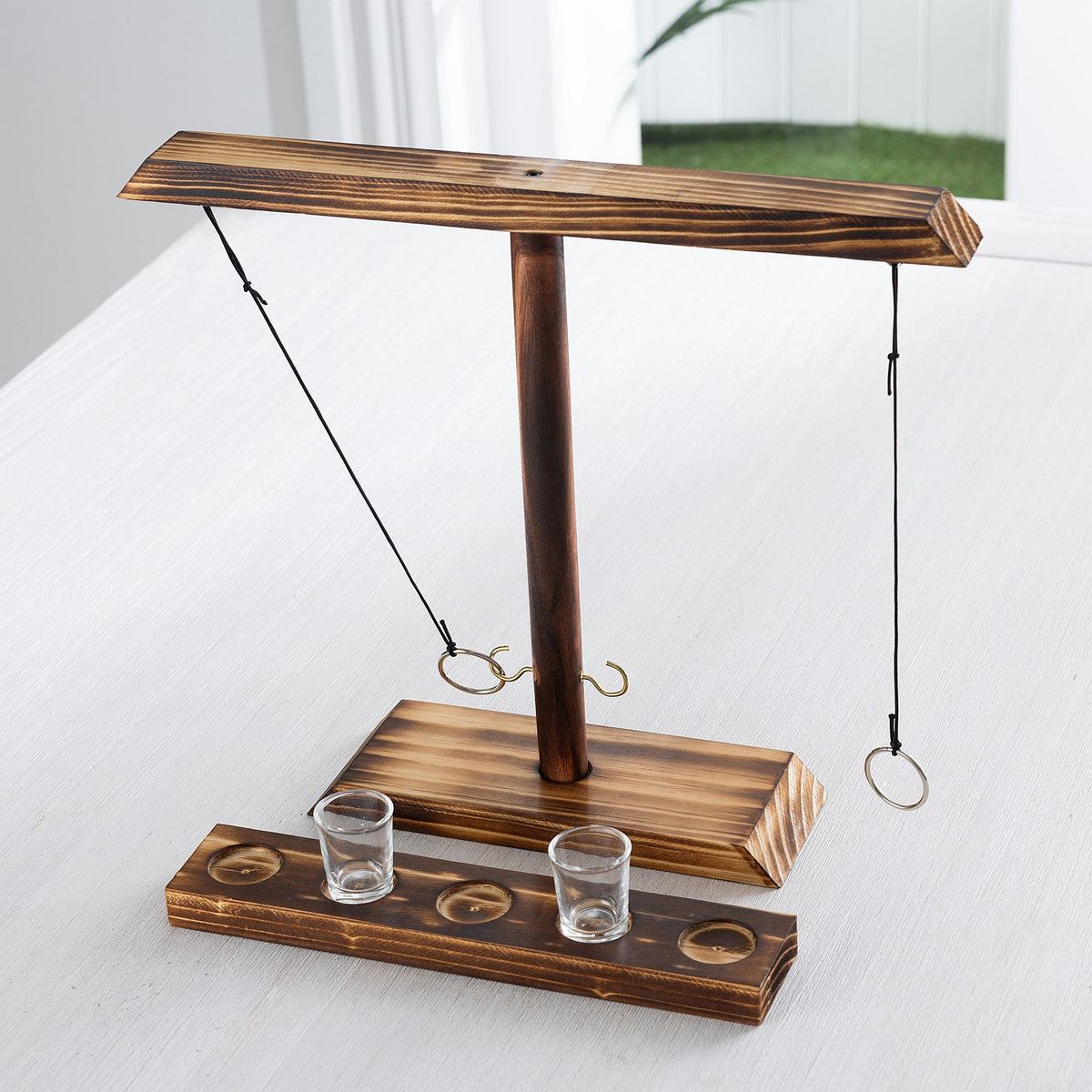 Play The Field ring toss game set featuring a wooden stand, hanging rings and two shot glasses with wooden holder.