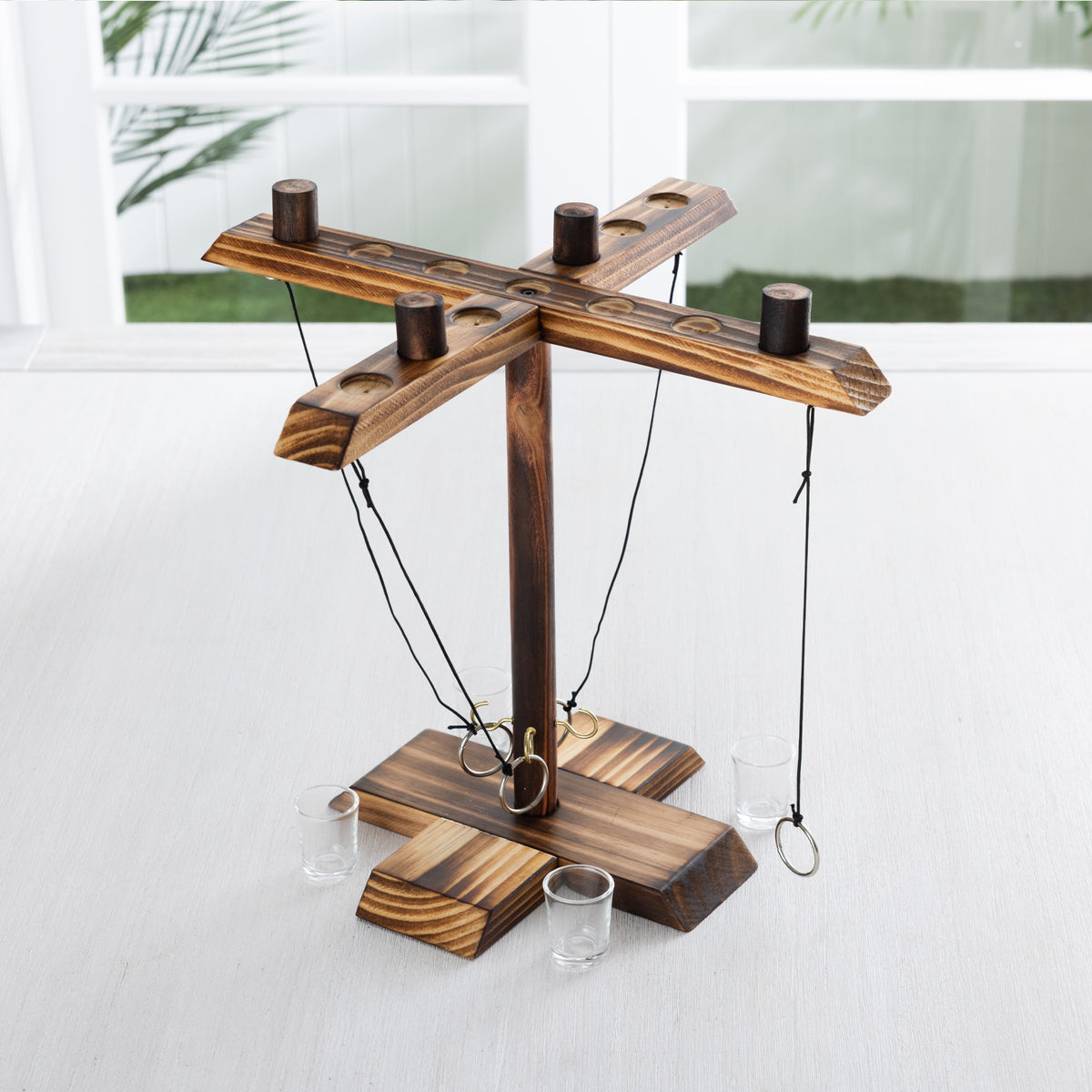  Play The Field ring toss game set featuring a wooden four-player stand with hanging rings, hooks and shot glasses displayed on a tabletop.
