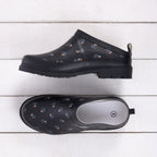 Outsidings Scuff Piwakawaka in Black, featuring a black slip-on design with scattered piwakawaka bird motifs and a chunky black sole.