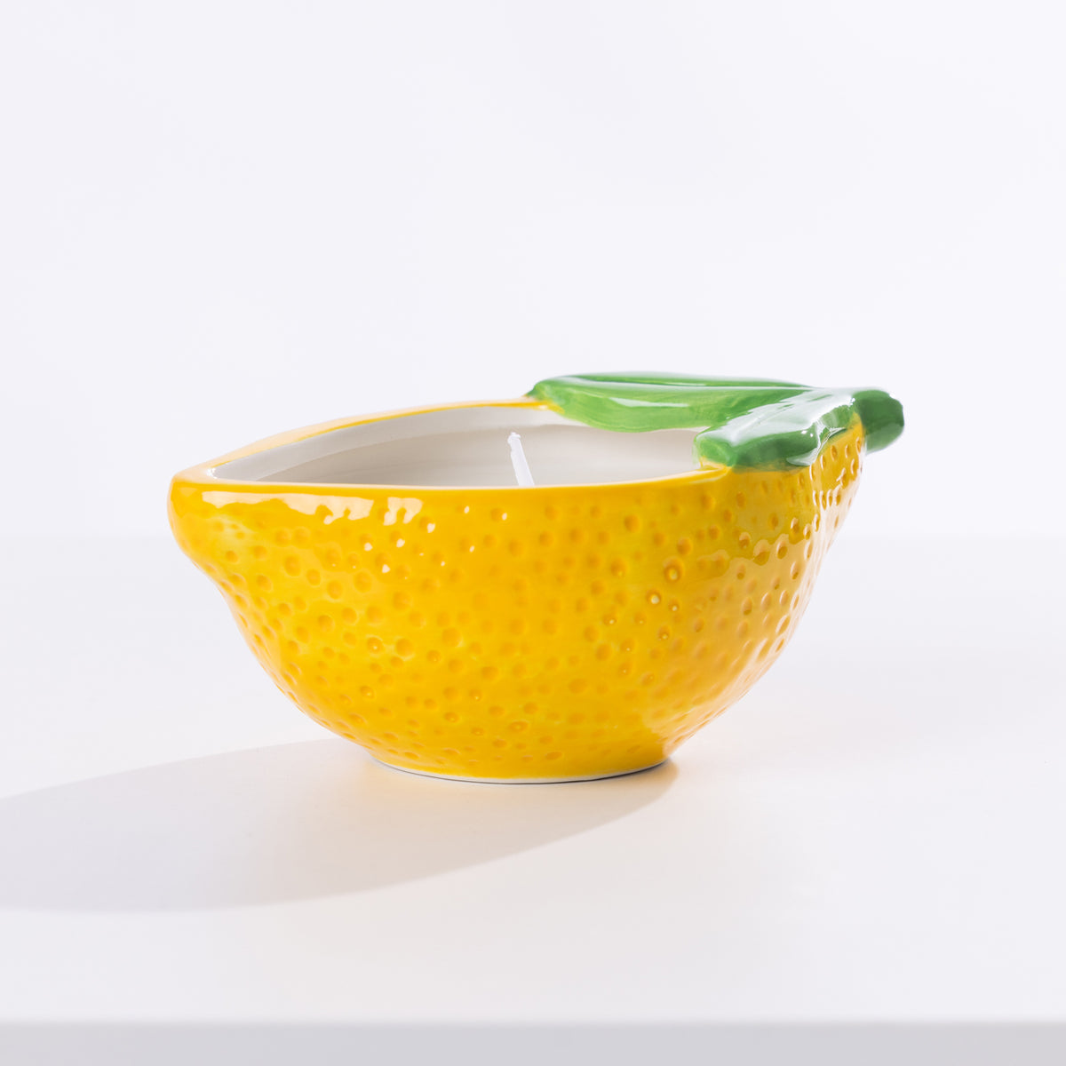 A citronella candle in a lemon holder