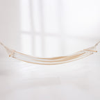 Natural and white striped hammock suspended with wooden spreader bars against a light background.