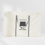 An off-white canvas storage bag  for a Giant 4-in-a-row game with black striped handles on a white studio background.