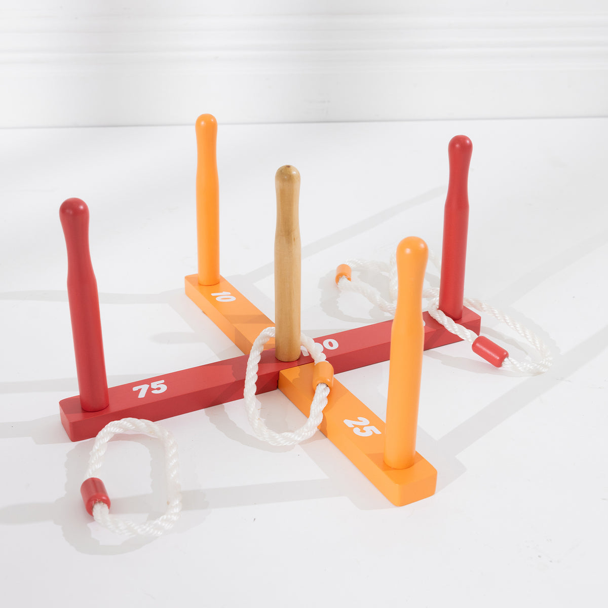 Colourful wooden ring toss game with red and orange numbered scoring pegs and white rope rings.