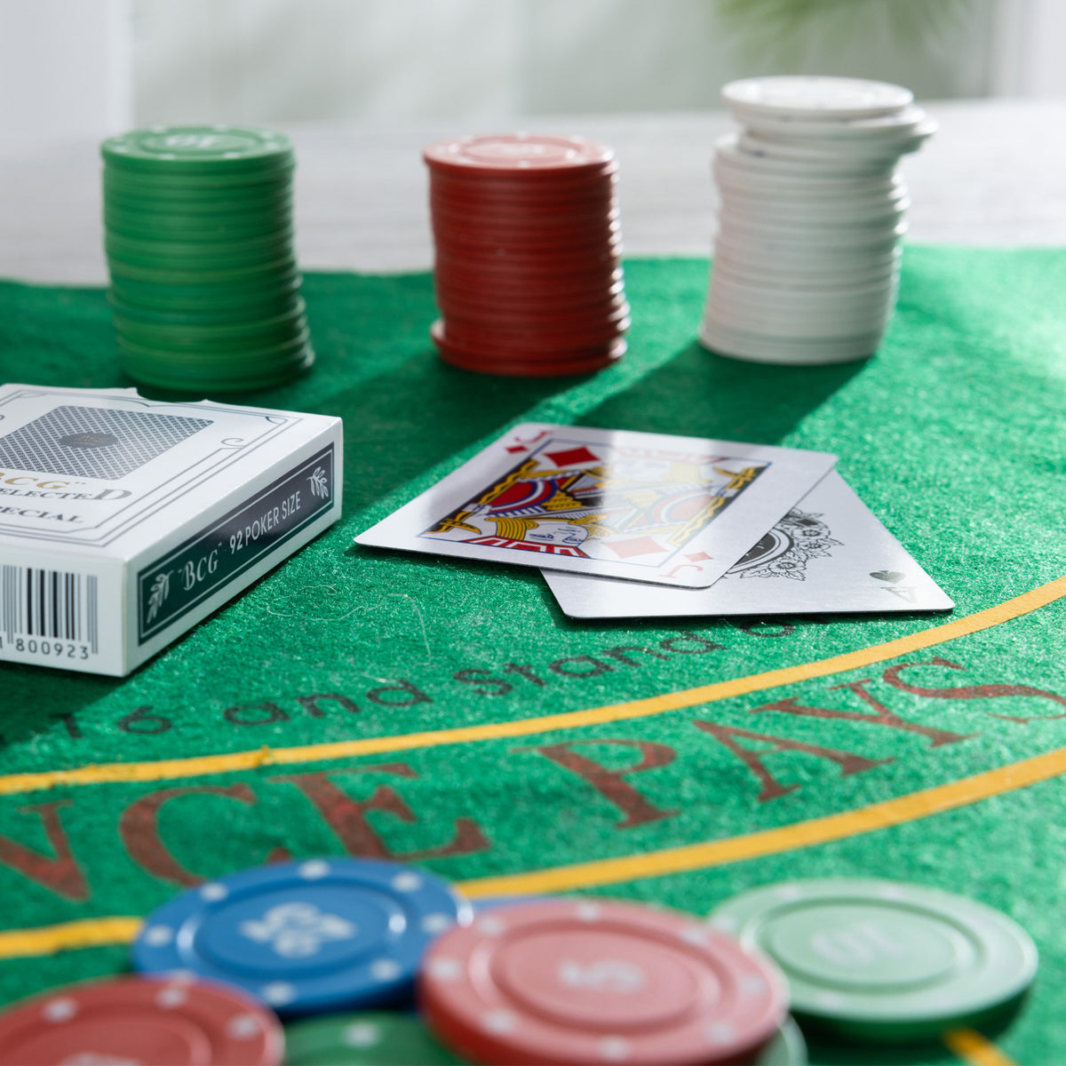 Close-up of the Play the Field Texas Card Set with colourful poker chips, playing cards and green felt gaming mat.