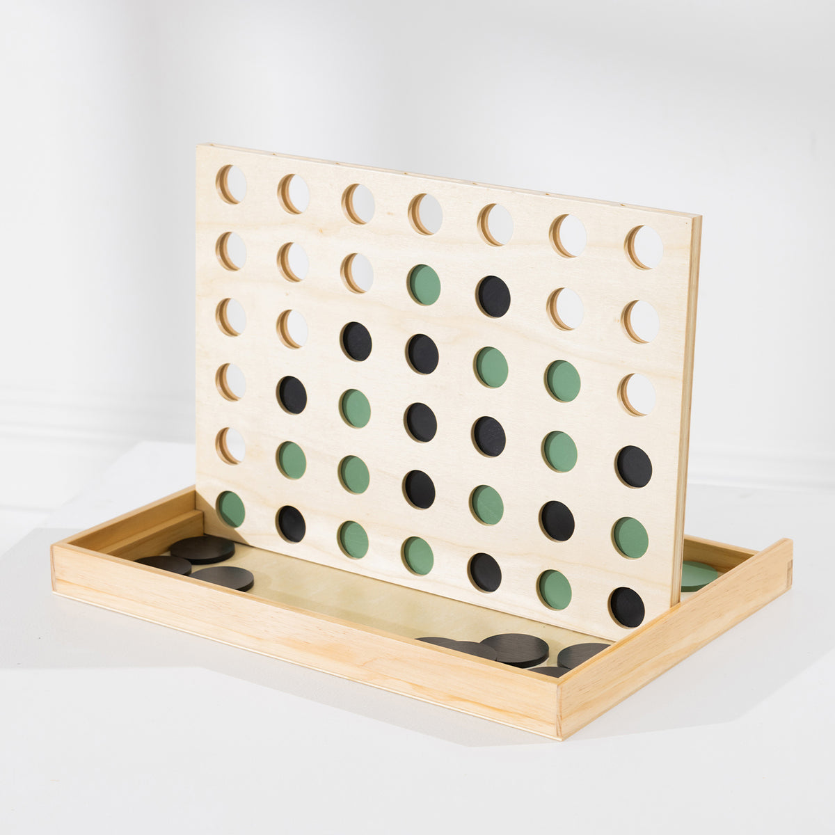 Play the Field 4-In-A-Row wooden game board with green and black wooden coins arranged in the grid.