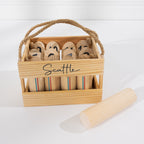 Play the Field Scattle wooden game set packed in its natural timber carry crate with rope handle, with a wooden throwing baton beside it.