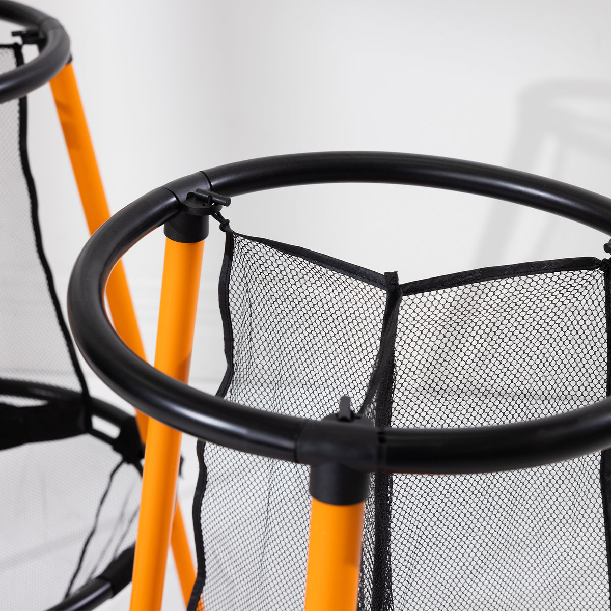 Close-up of the black circular frame, orange legs and mesh netting of the Play the Field Disc Target Game.