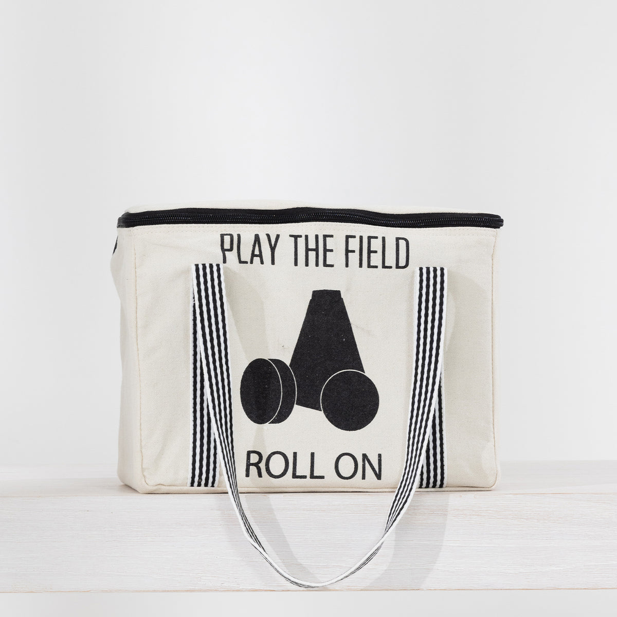 Play The Field Roll On Game packed inside a cream canvas zip bag with black striped handles.