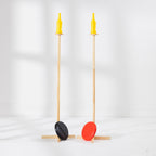 Play The Field Disc Bottle Drop Game with two wooden stands, yellow bottles and red and black throwing discs.