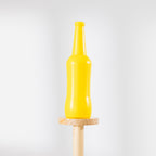 Close-up of a yellow bottle balanced on top of the wooden Disc Bottle Drop game stand.
