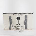 Play The Field Disc Bottle Drop Game packed inside a cream canvas zip bag with black striped handles.