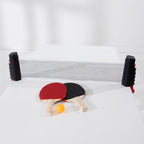 Play the Field Table Tennis Set featuring an adjustable net, red and black paddles and an orange table tennis ball.