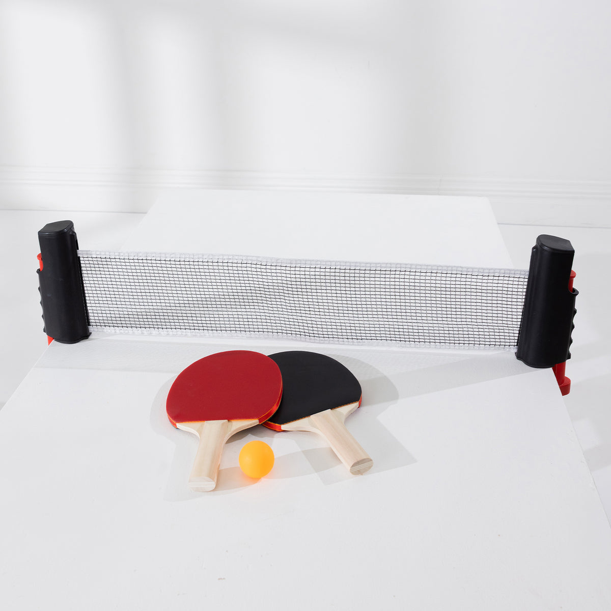 Play the Field Table Tennis Set featuring an adjustable net, red and black paddles and an orange table tennis ball.