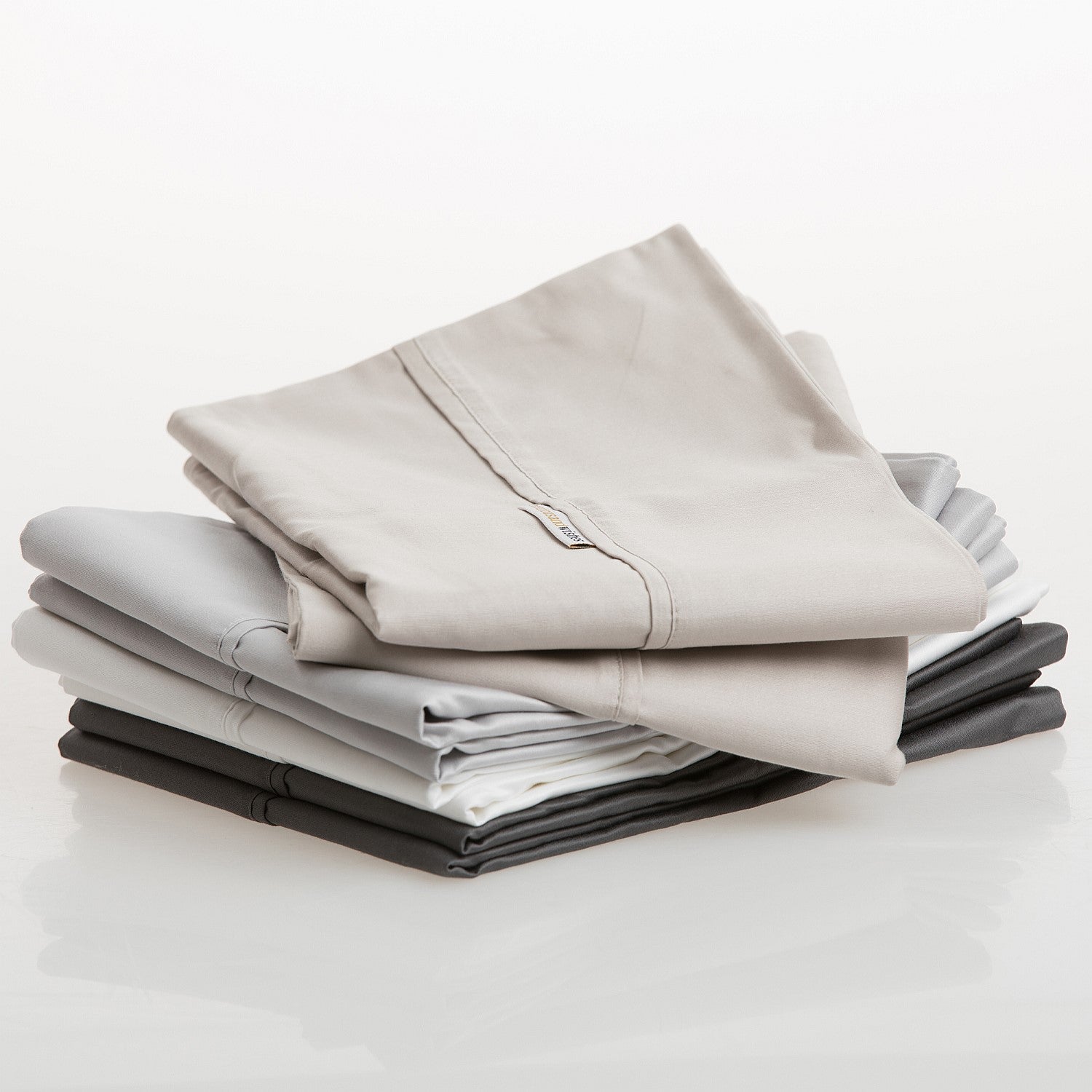 Stack of folded gray and black pillowcases on a white background