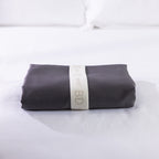 A neatly folded body pillowcase is secured with a reusable branded storage band, showcasing premium presentation and effortless linen organisation.