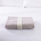 A neatly folded body pillowcase is secured with a reusable branded storage band, showcasing premium presentation and effortless linen organization.
