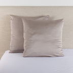 Silver taupe satin Euro pillowcase pair styled on a bed against a neutral upholstered headboard.