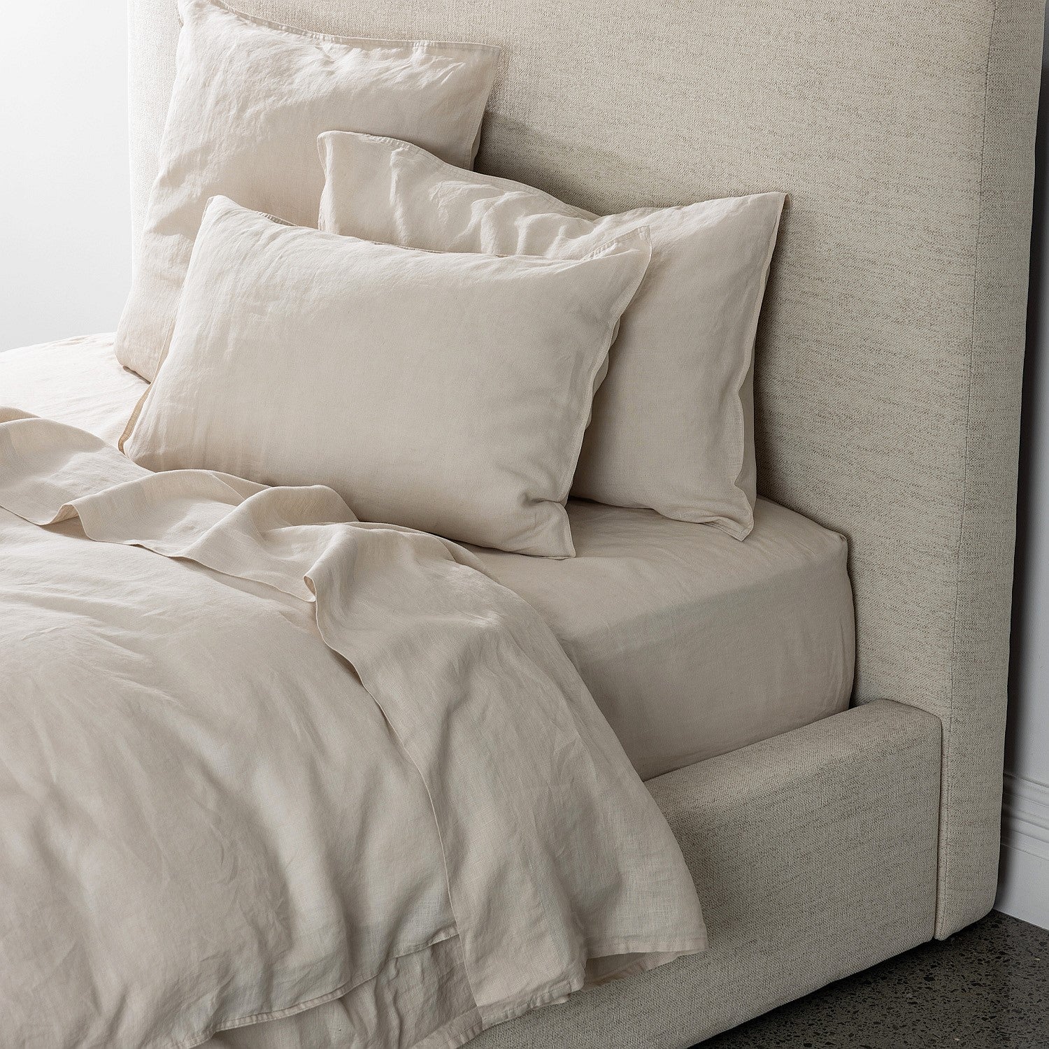 Beige bedding set on a bed with a neutral headboard