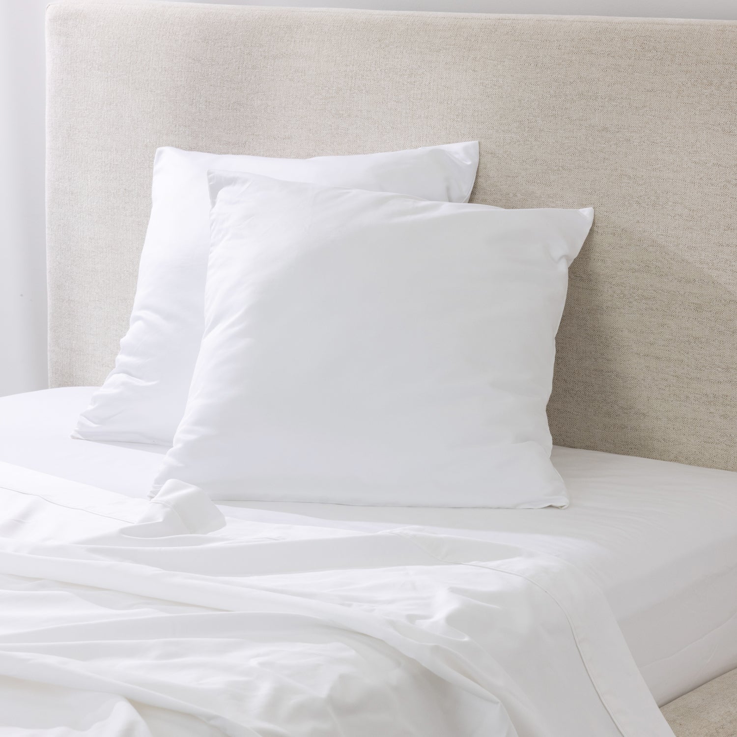 A pair of crisp white European pillowcases is beautifully styled on a freshly made bed, creating a clean, timeless and luxurious bedroom aesthetic.