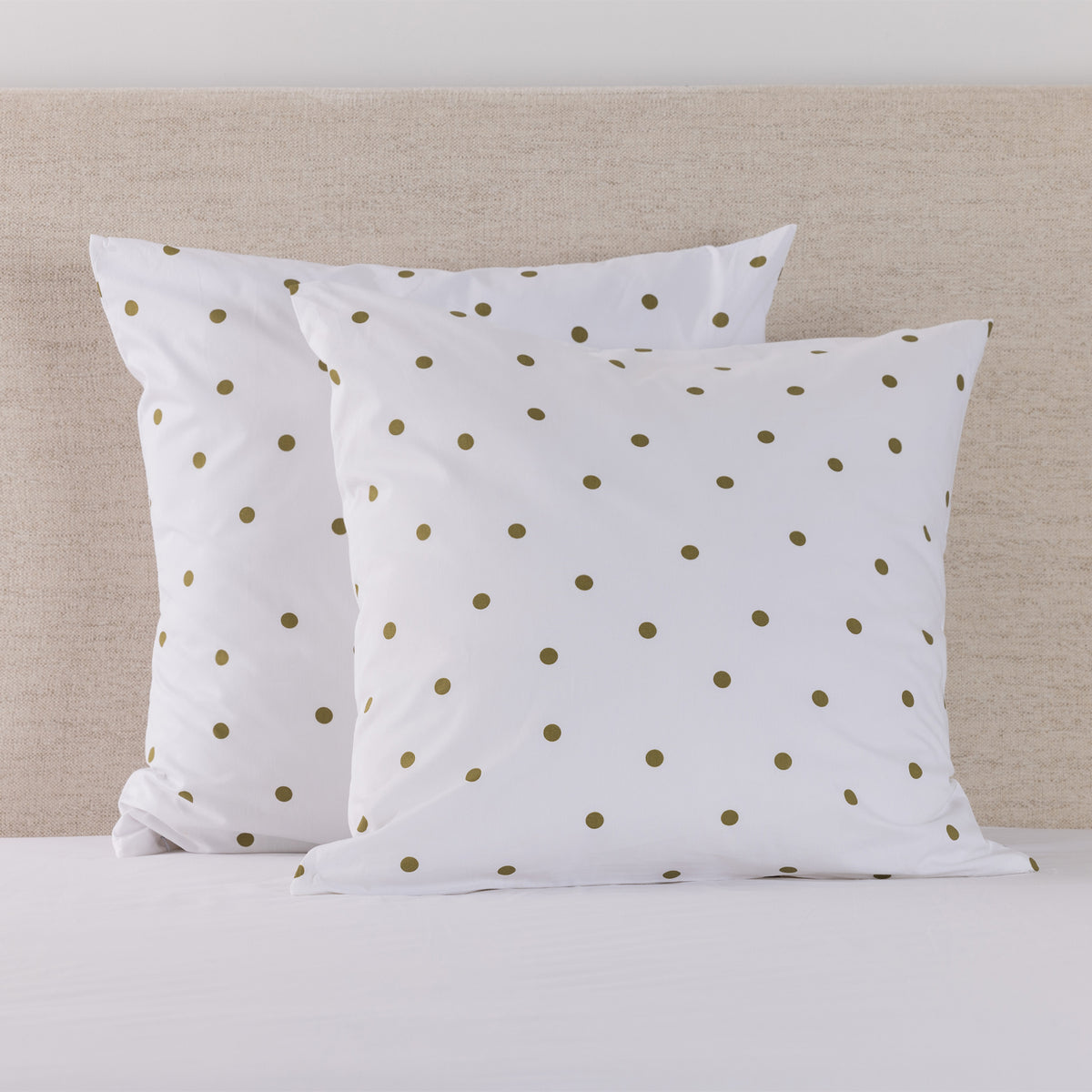 Pure & Simple Monroe European Pillowcase Pair in grey with white polka dots, styled on a bed against a neutral upholstered headboard.