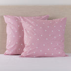 Pure & Simple Monroe European Pillowcases in blush, featuring a white polka dot design, styled on a bed against a neutral upholstered headboard.