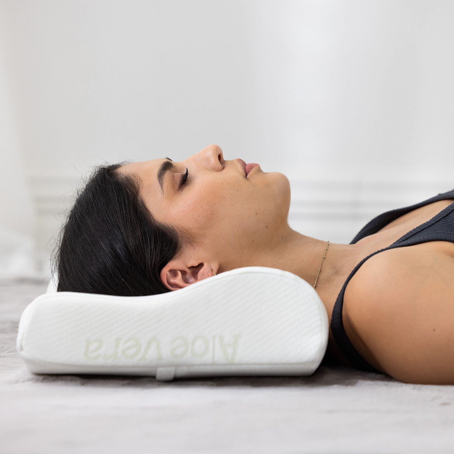 Person lying on Aloe Vera contour memory foam pillow showing ergonomic neck and head support.