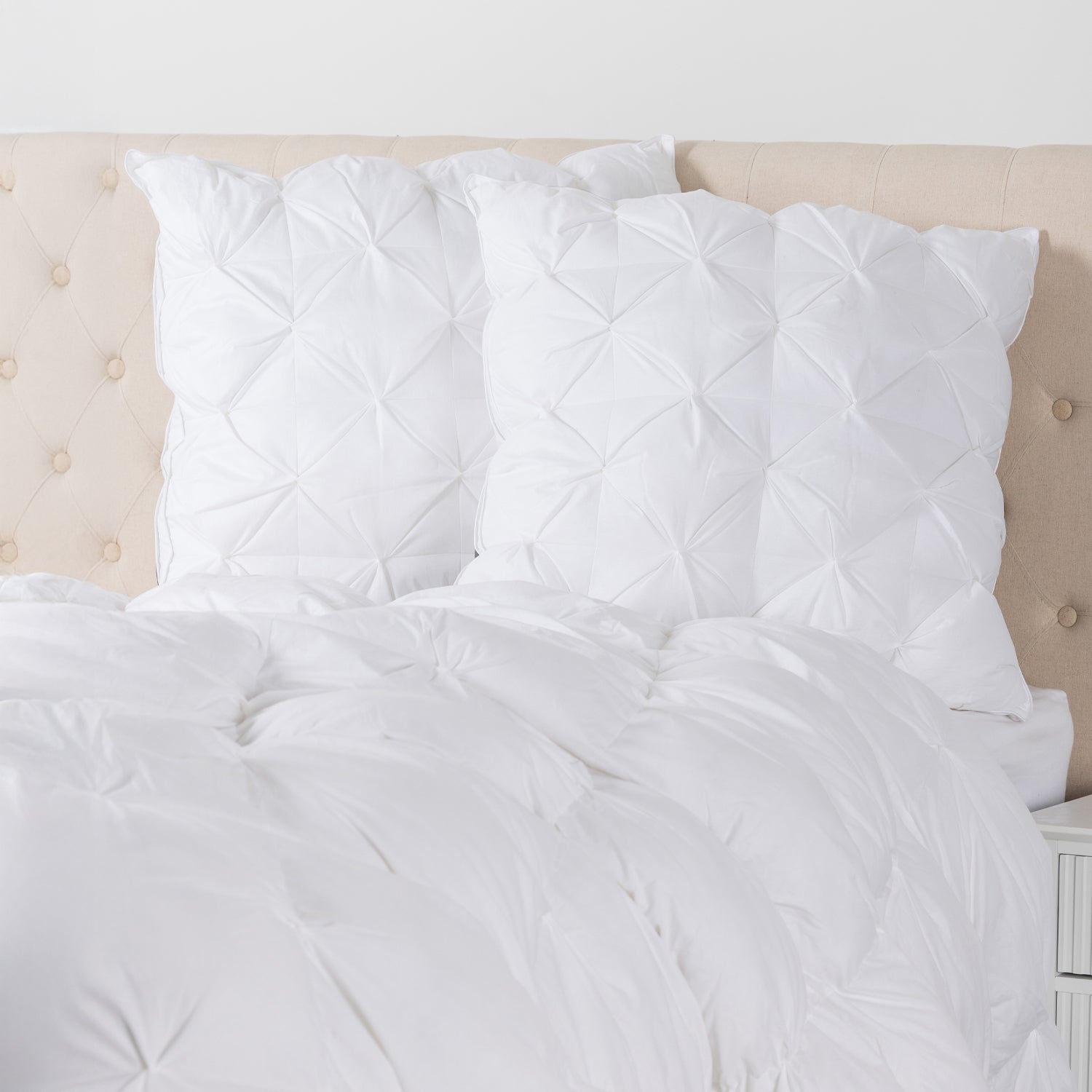 European pillows with elegant pinch-pleat detailing displayed on a bed, adding texture, comfort, and a sophisticated finishing touch to the bedroom.