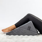 Solace Multi-Purpose Wedge Support Pillow arranged beneath bent knees for additional lower-body support.
