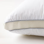 Close-up of an adjustable pillow featuring a removable foam support layer and zippered construction for customised comfort.