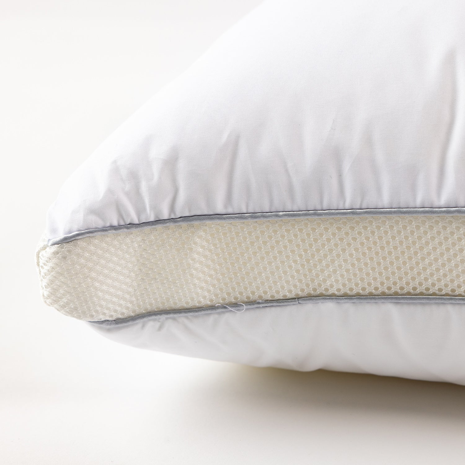 Close-up of an adjustable pillow featuring a removable foam support layer and zippered construction for customised comfort.
