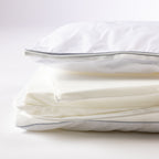 Layered adjustable pillow shown with removable foam inserts and zip closure for customised comfort and support.