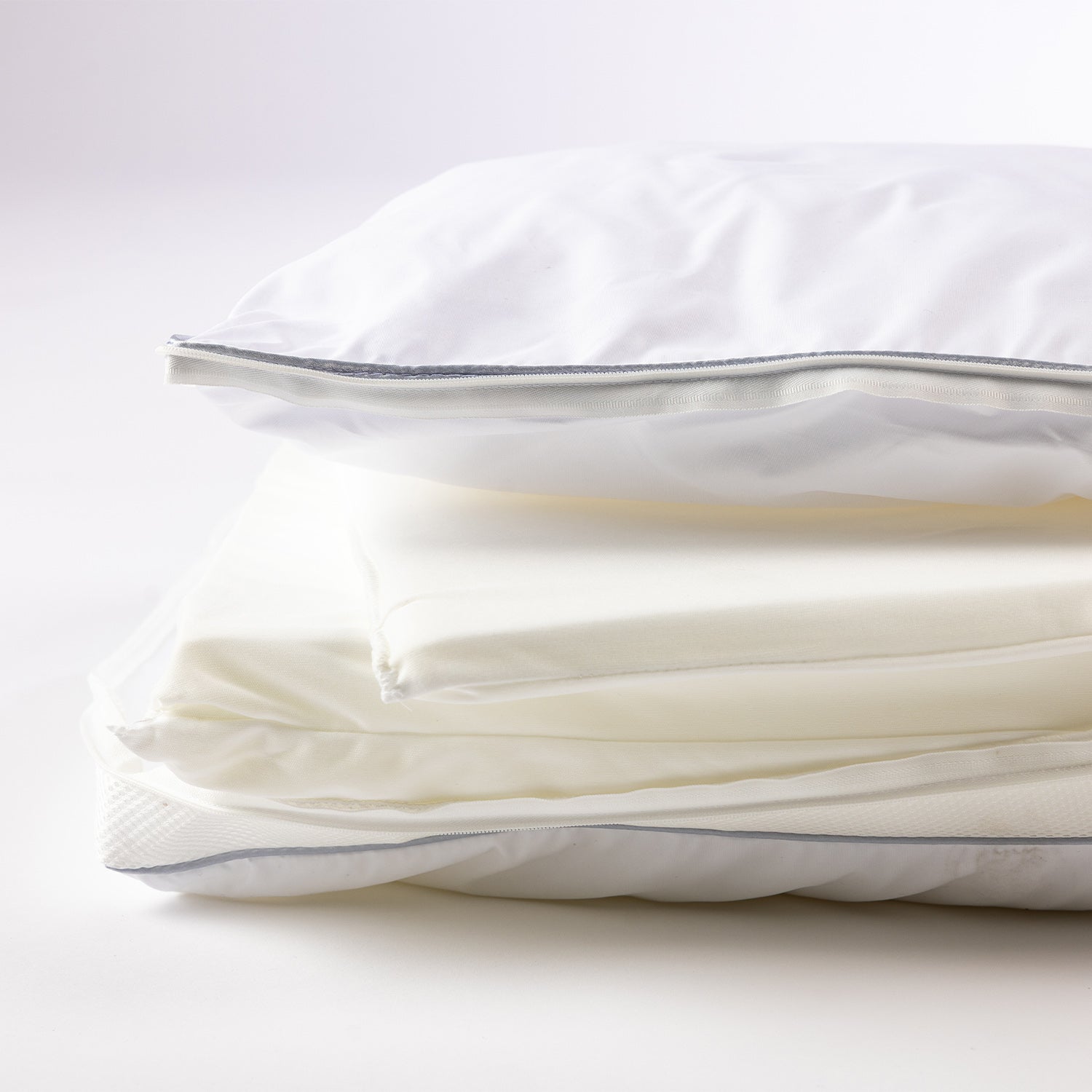 Layered adjustable pillow shown with removable foam inserts and zip closure for customised comfort and support.