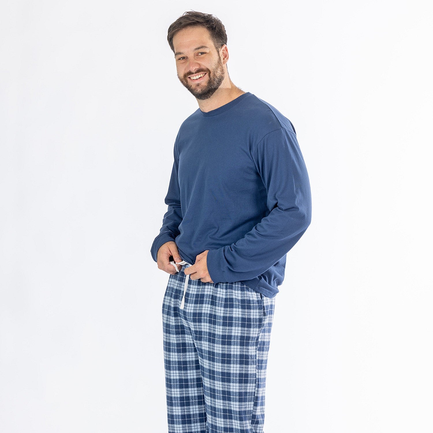 Man wearing a blue long sleeve top with blue check flannelette pyjama pants.