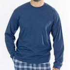 Close up of a man wearing a blue long sleeve top with blue check flannelette pyjama pants.