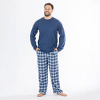 Man wearing a blue long sleeve top with blue check flannelette pyjama pants.